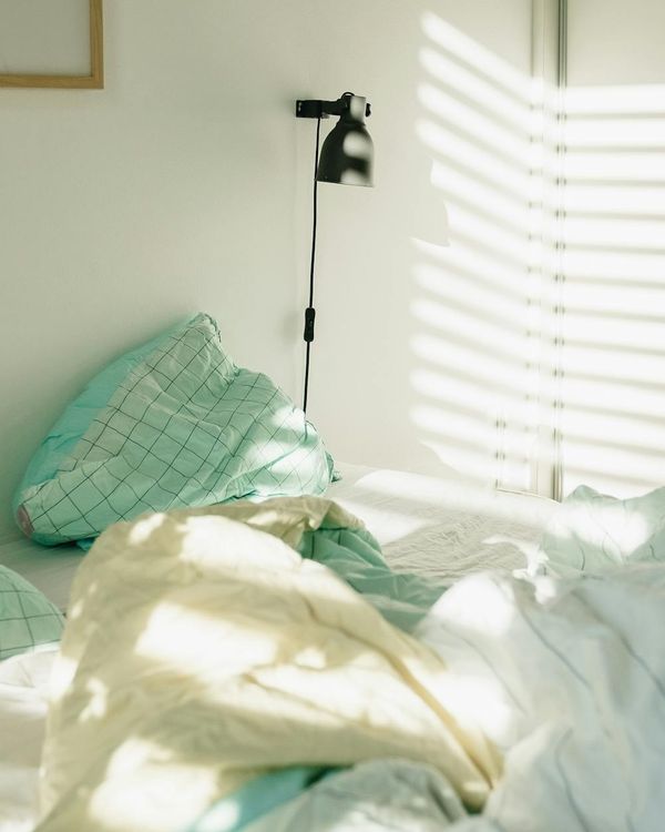 Cozy and clean corner of a room with a yoga mat, a plant, and soft morning light.