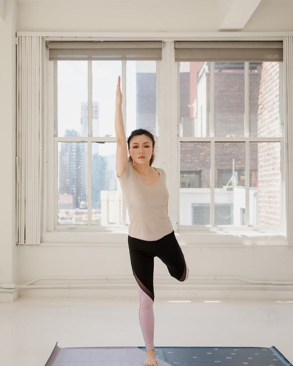 Person in a balanced warrior three yoga pose, showing focus and stability.